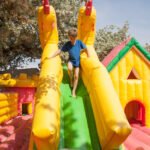 Young boy playing in an inflatable toy house in a park